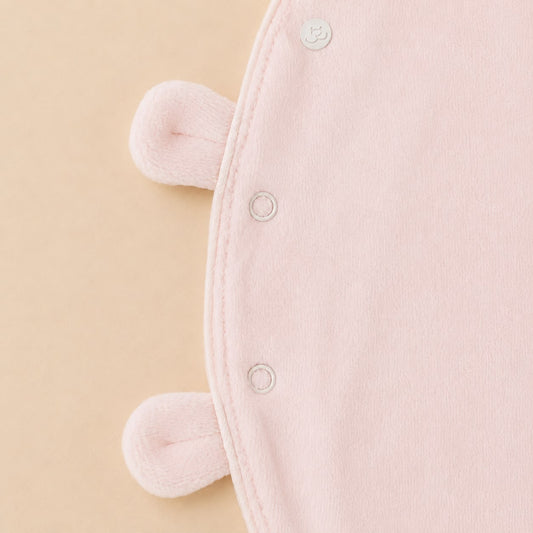De sluiting details van het roze velourse baby pakje