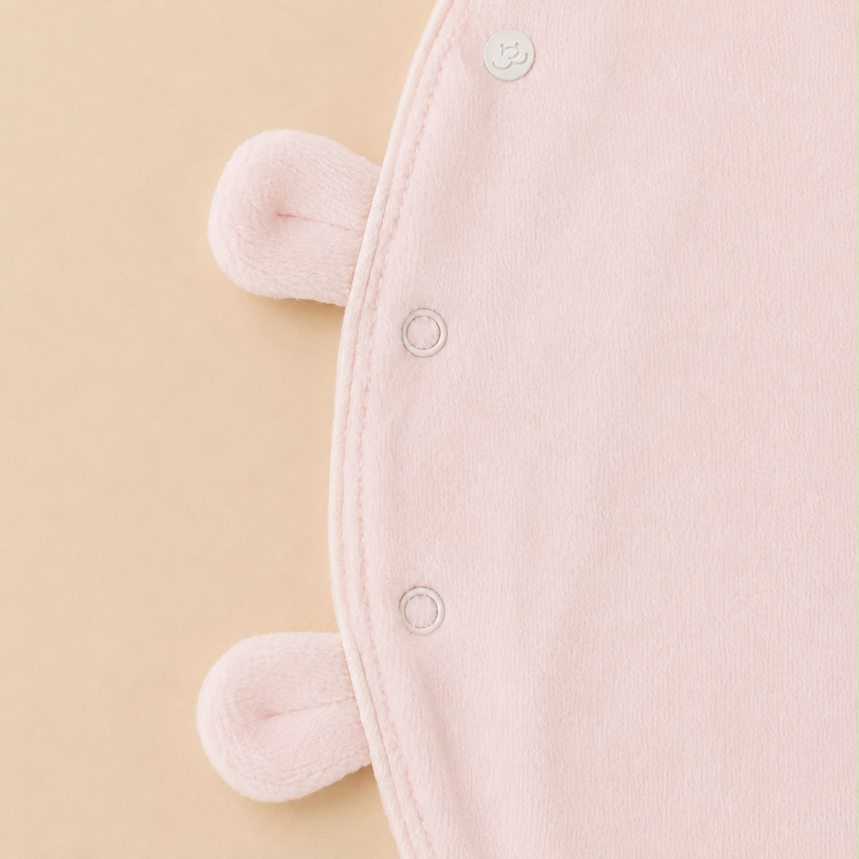 De sluiting details van het roze velourse baby pakje