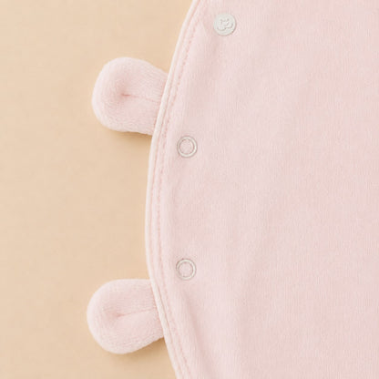 De sluiting details van het roze velourse baby pakje