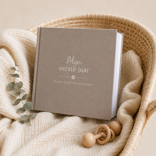 Een linnen hardkaft baby invulboek 'mijn eerste jaar' voor mijlpalen en bijzondere herinneringen in de kleur taupe