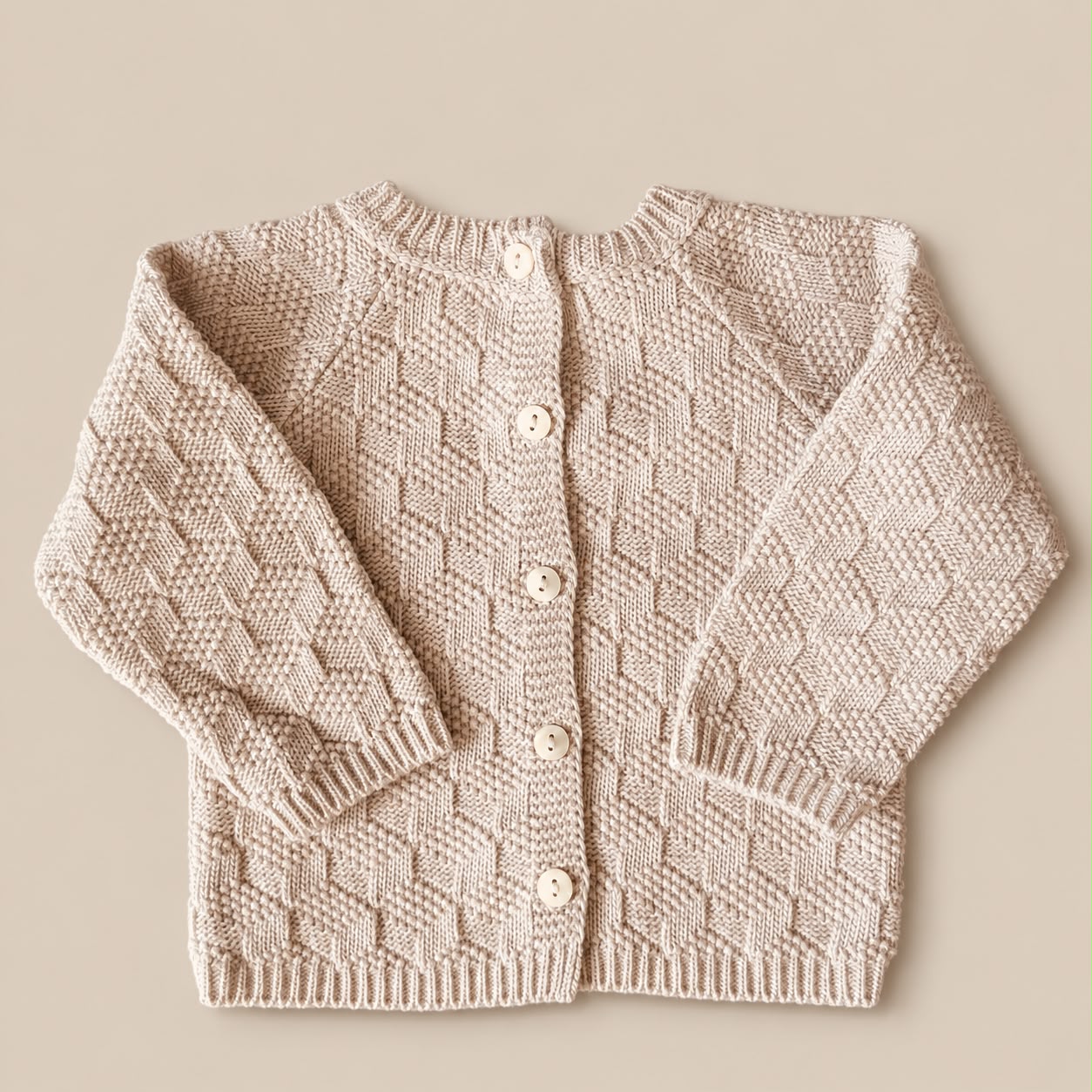 Zandbeige truitje met motief en knopen achter